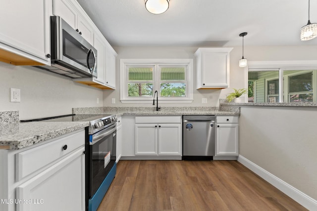 2518 El Viernes St, Gautier, MS 39553 - kitchen featuring stainless steel appliances, white cabinetry, dark wood finished floors, and decorative light fixtures
