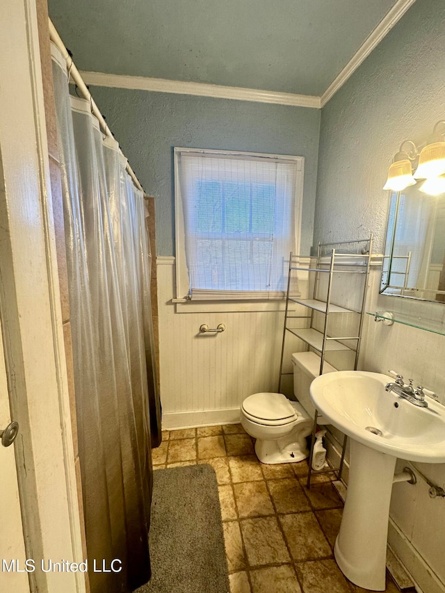 bathroom with toilet, ornamental molding, and walk in shower