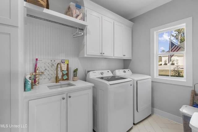 laundry area featuring cabinets, sink, and washing machine and clothes dryer