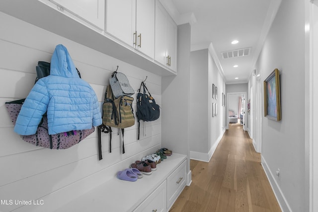 mudroom with light hardwood / wood-style flooring and ornamental molding