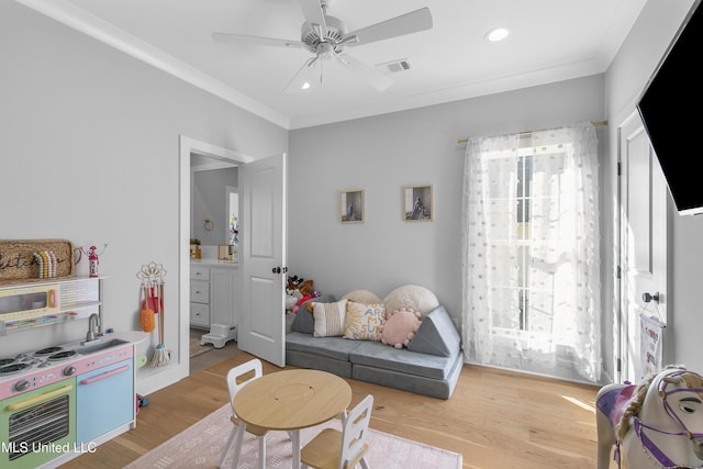 interior space with ornamental molding, ceiling fan, and light wood-type flooring