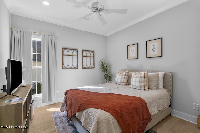 bedroom featuring ornamental molding, ceiling fan, and light wood-type flooring