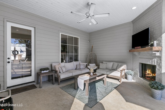 living room featuring wooden ceiling, wooden walls, ceiling fan, a fireplace, and carpet