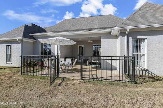 rear view of house featuring a patio, ceiling fan, and a lawn