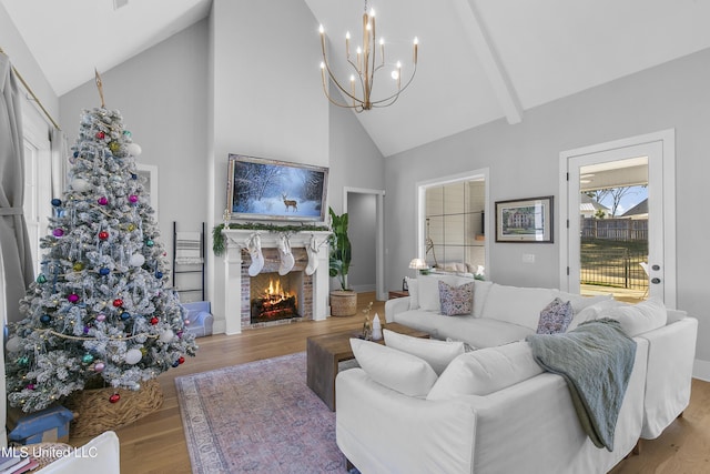 living room featuring high vaulted ceiling, a chandelier, and hardwood / wood-style floors