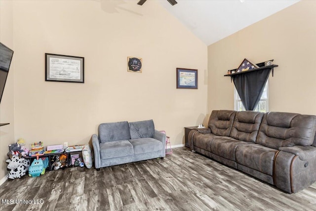 living room featuring ceiling fan, hardwood / wood-style flooring, and vaulted ceiling