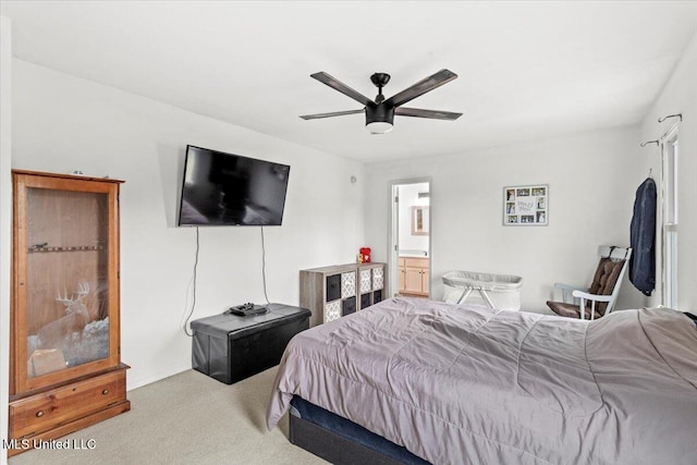 carpeted bedroom featuring ceiling fan and ensuite bathroom