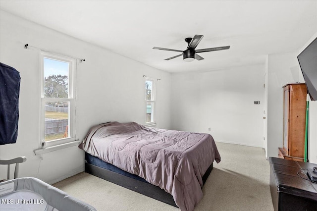 carpeted bedroom featuring ceiling fan and multiple windows