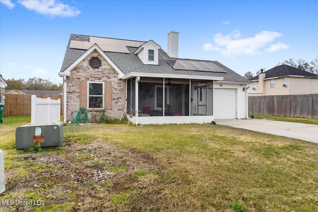 view of front of property with a front lawn, a garage, solar panels, and a sunroom