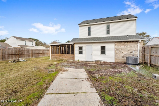 back of property featuring a sunroom, a yard, and central air condition unit