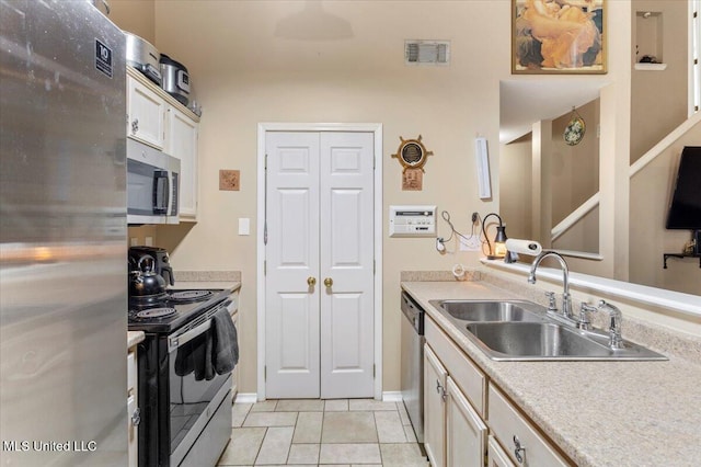 kitchen featuring light tile patterned floors, stainless steel appliances, and sink