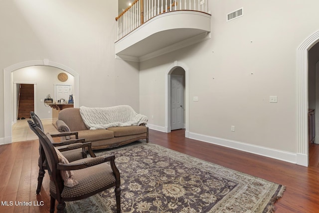 living room with dark hardwood / wood-style flooring and a towering ceiling