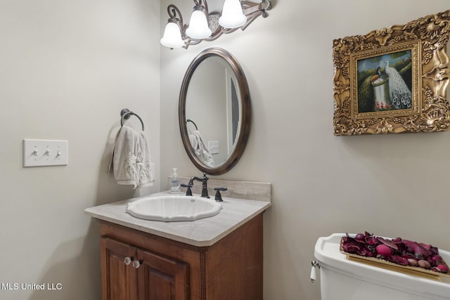 bathroom featuring vanity, a chandelier, and toilet