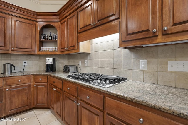 kitchen with light stone counters, stainless steel gas cooktop, tasteful backsplash, and light tile patterned floors