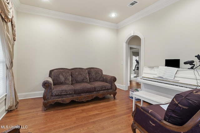 sitting room with wood-type flooring and ornamental molding