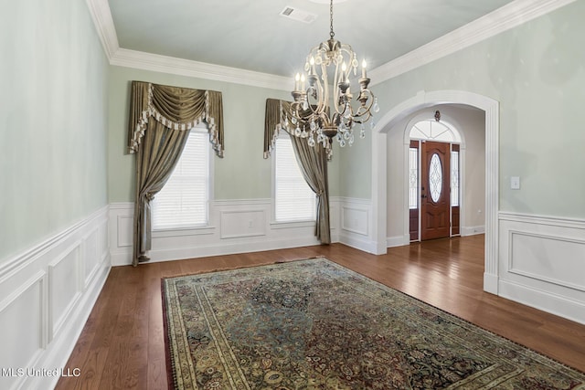 foyer entrance featuring dark hardwood / wood-style flooring, a chandelier, and a healthy amount of sunlight