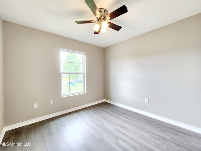unfurnished room featuring baseboards, ceiling fan, and wood finished floors