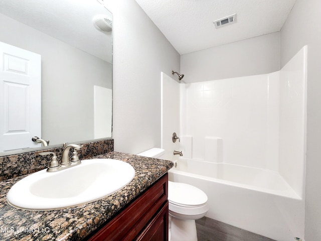 bathroom featuring visible vents, vanity, wood finished floors, toilet, and shower / washtub combination