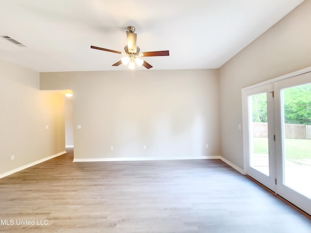unfurnished room featuring a ceiling fan, baseboards, visible vents, and light wood finished floors