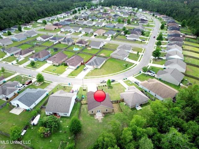 drone / aerial view featuring a residential view and a wooded view