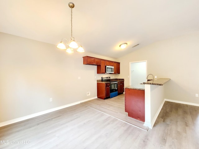 kitchen featuring an inviting chandelier, light wood-style flooring, appliances with stainless steel finishes, and lofted ceiling