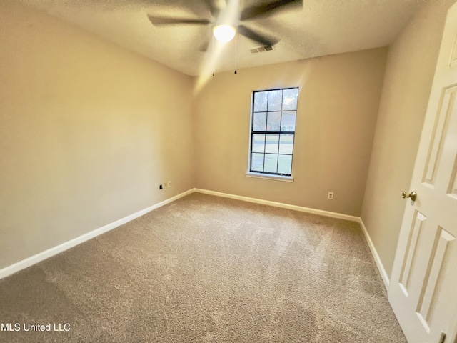 unfurnished room featuring ceiling fan, carpet floors, and a textured ceiling