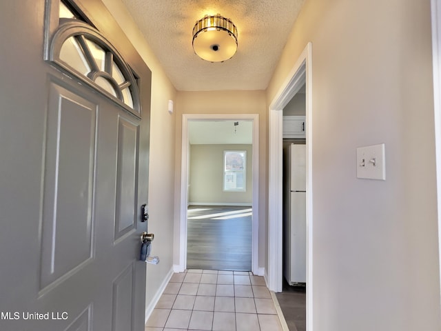 entryway featuring light tile patterned flooring and a textured ceiling