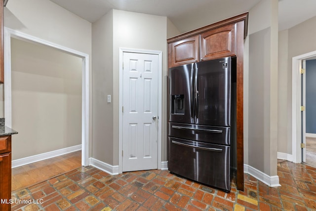 10566 W River Vue, Biloxi, MS 39532 - kitchen featuring stainless steel fridge, dark stone countertops, and brick floors
