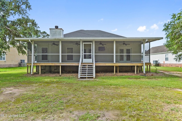 10566 W River Vue, Biloxi, MS 39532 - back of house with a ceiling fan, a lawn, a chimney, a deck, and roof with shingles
