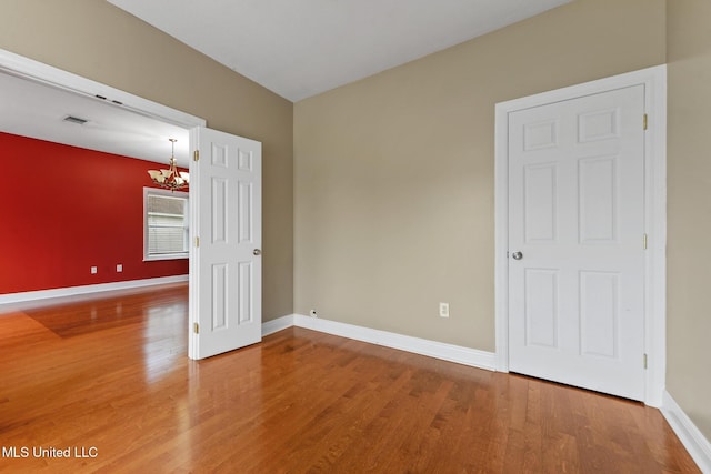 10566 W River Vue, Biloxi, MS 39532 - empty room with a chandelier and wood finished floors