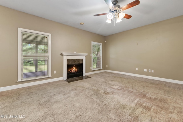 10566 W River Vue, Biloxi, MS 39532 - unfurnished living room featuring carpet, a high end fireplace, and a ceiling fan