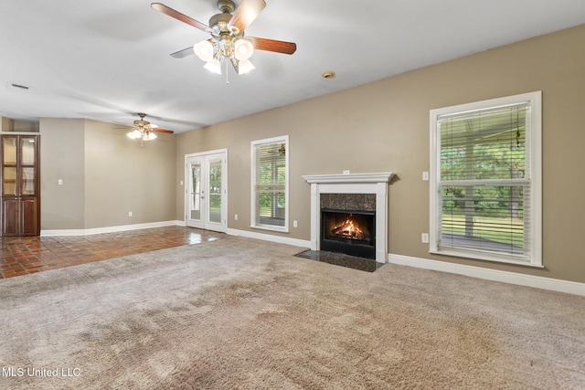 10566 W River Vue, Biloxi, MS 39532 - unfurnished living room featuring a ceiling fan, carpet floors, a high end fireplace, and french doors