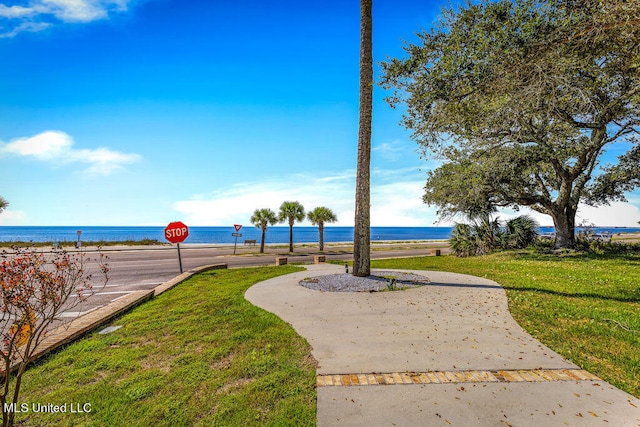 view of community with a lawn and a water view