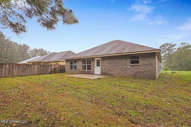 back of property featuring a yard and a patio