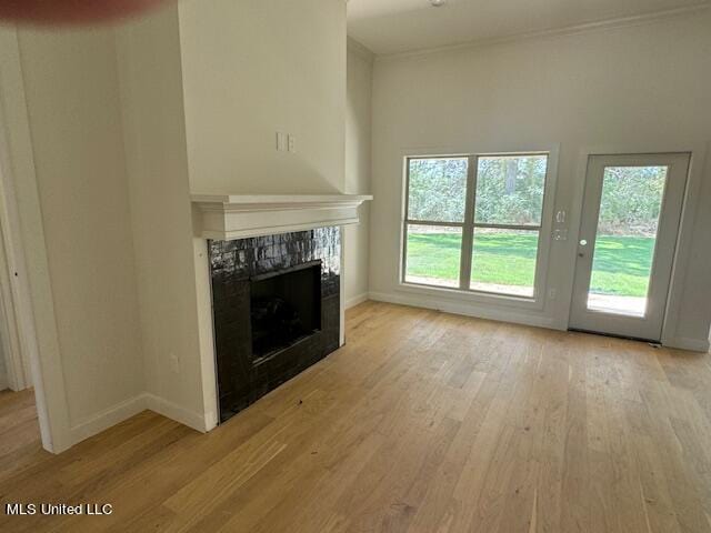 unfurnished living room with light hardwood / wood-style floors and a tiled fireplace