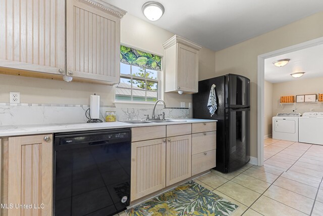 211 Demontluzin Ave, Bay Saint Louis, MS 39520 - kitchen with black appliances, washing machine and clothes dryer, a sink, light tile patterned floors, and light brown cabinetry