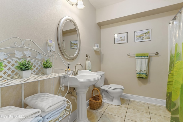211 Demontluzin Ave, Bay Saint Louis, MS 39520 - bathroom featuring tile patterned floors, toilet, and baseboards