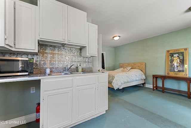 211 Demontluzin Ave, Bay Saint Louis, MS 39520 - bedroom featuring a sink, finished concrete flooring, and baseboards
