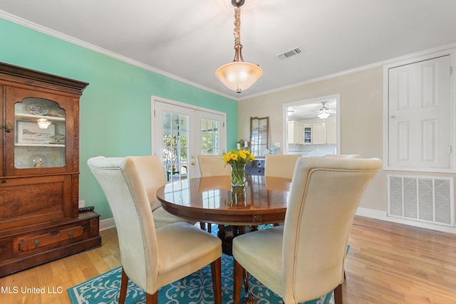 211 Demontluzin Ave, Bay Saint Louis, MS 39520 - dining space with light wood-type flooring, crown molding, baseboards, ceiling fan, and french doors