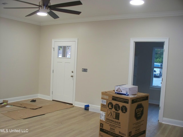 foyer with ornamental molding, light hardwood / wood-style flooring, and ceiling fan