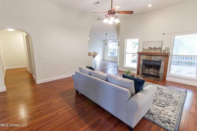 living room with baseboards, arched walkways, ceiling fan, and visible vents