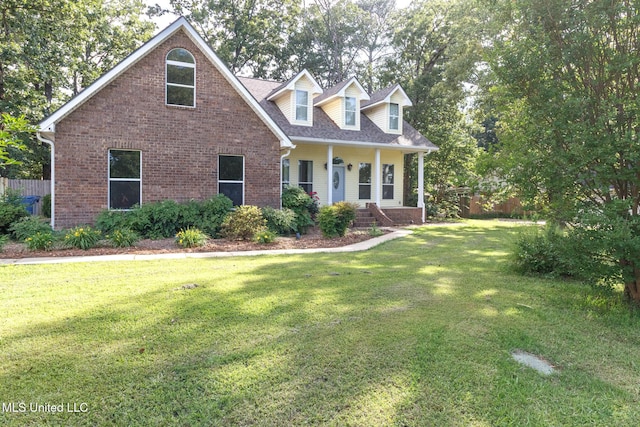 cape cod-style house with brick siding, fence, and a front yard