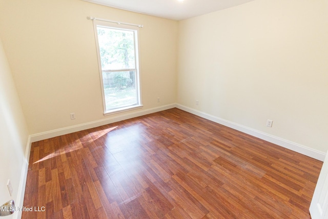 empty room featuring baseboards and wood finished floors