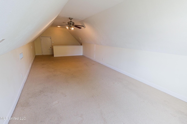 bonus room with a ceiling fan, baseboards, light carpet, and vaulted ceiling
