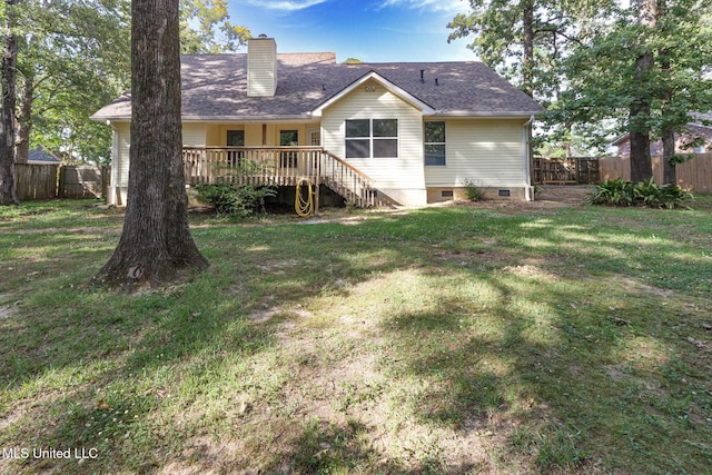 rear view of house with a lawn, a wooden deck, a fenced backyard, and a chimney