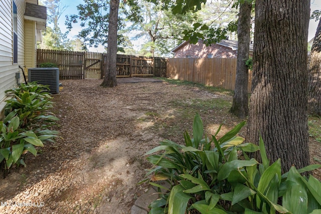 view of yard with central AC and fence