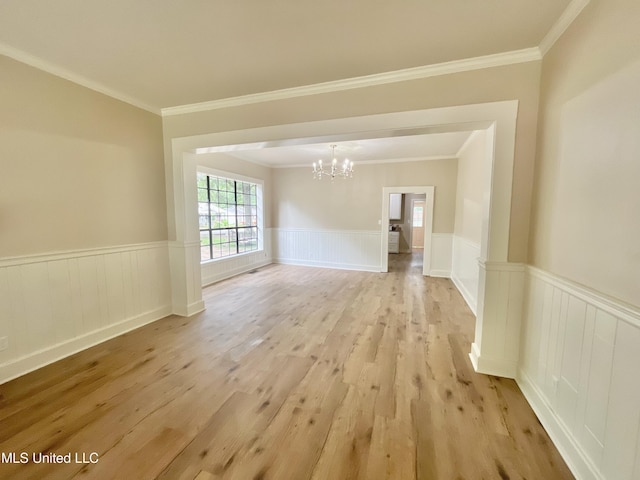 708 Lee Ave, Crystal Springs, MS 39059 - unfurnished room featuring a chandelier, light wood-type flooring, wainscoting, and ornamental molding