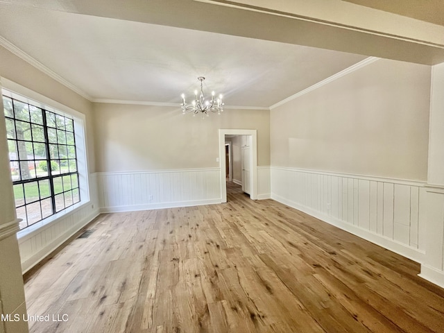 708 Lee Ave, Crystal Springs, MS 39059 - unfurnished dining area featuring a chandelier, wood finished floors, ornamental molding, and a wainscoted wall