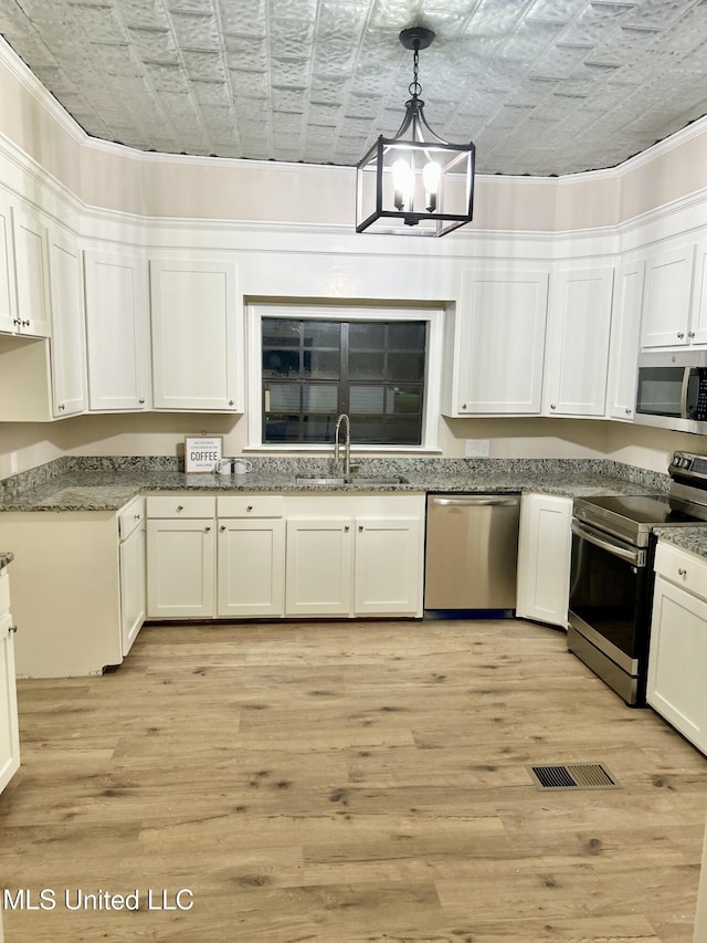 708 Lee Ave, Crystal Springs, MS 39059 - kitchen with appliances with stainless steel finishes, an ornate ceiling, white cabinets, light wood-style floors, and a chandelier