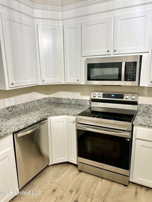 708 Lee Ave, Crystal Springs, MS 39059 - kitchen with stainless steel appliances, light wood-type flooring, and white cabinets